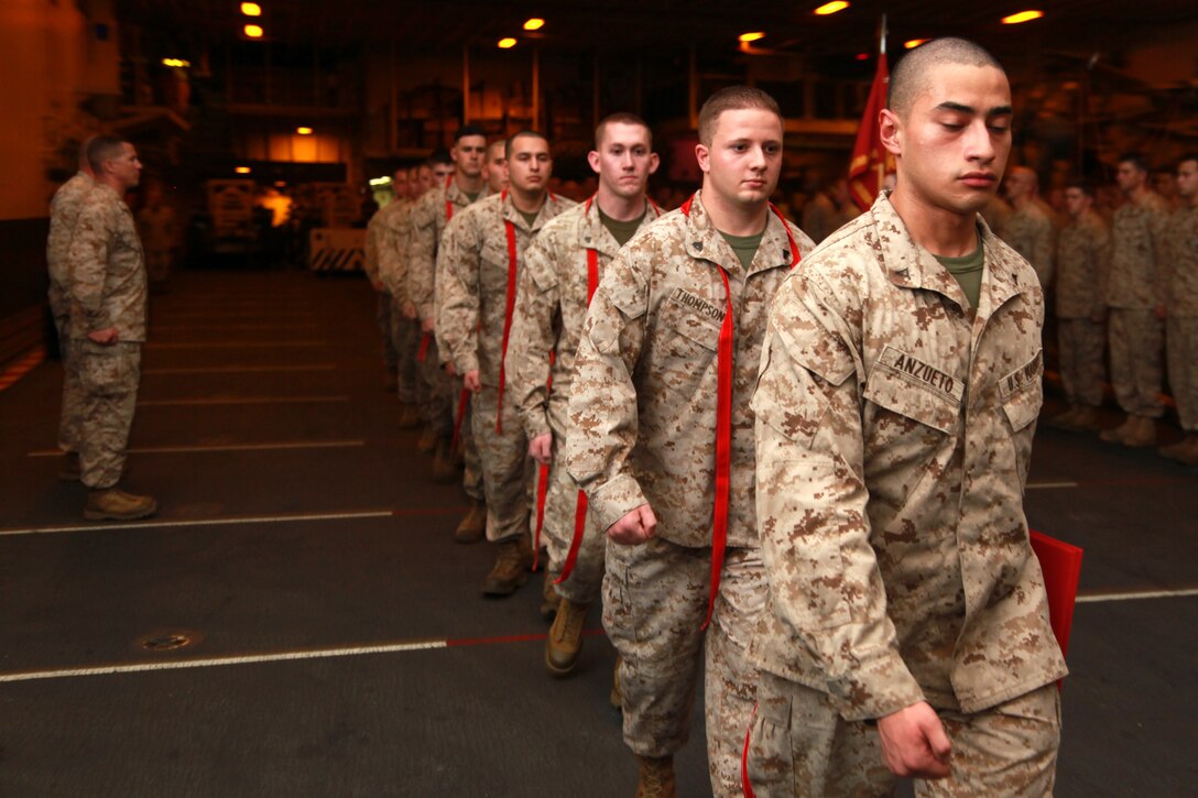 Marines with Marine Medium Helicopter Squadron 364 (Rein.), 15th Marine Expeditionary Unit, post after being awarded or promoted during an awards and promotions ceremony held in the hangar bay of the USS Peleliu, Jan. 1. Marine Medium Helicopter Squadron 364 (Rein.) serves as the aviation combat element for the 15th MEU. The 15th MEU is deployed as part of the Peleliu Amphibious Ready Group as a U.S. Central Command theater reserve force, providing support for maritime security operations and theater security cooperation efforts in the U.S. 5th Fleet area of responsibility. 