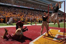 Goldy, University of Minnesota's mascot, watches Lance Cpl. Enrique A. Gutierrez hold the bar for Officer Selection Station Twin Cities' 1st Lt. Andrew Schroers during a pull-up challenge in the endzone at TCF Bank Stadium on Sept. 15. Schroers, 27, from Belle Plaine, Minn., had 30 seconds to complete as many pull-ups as possible. For additional imagery from the event, visit www.facebook.com/rstwincities.
