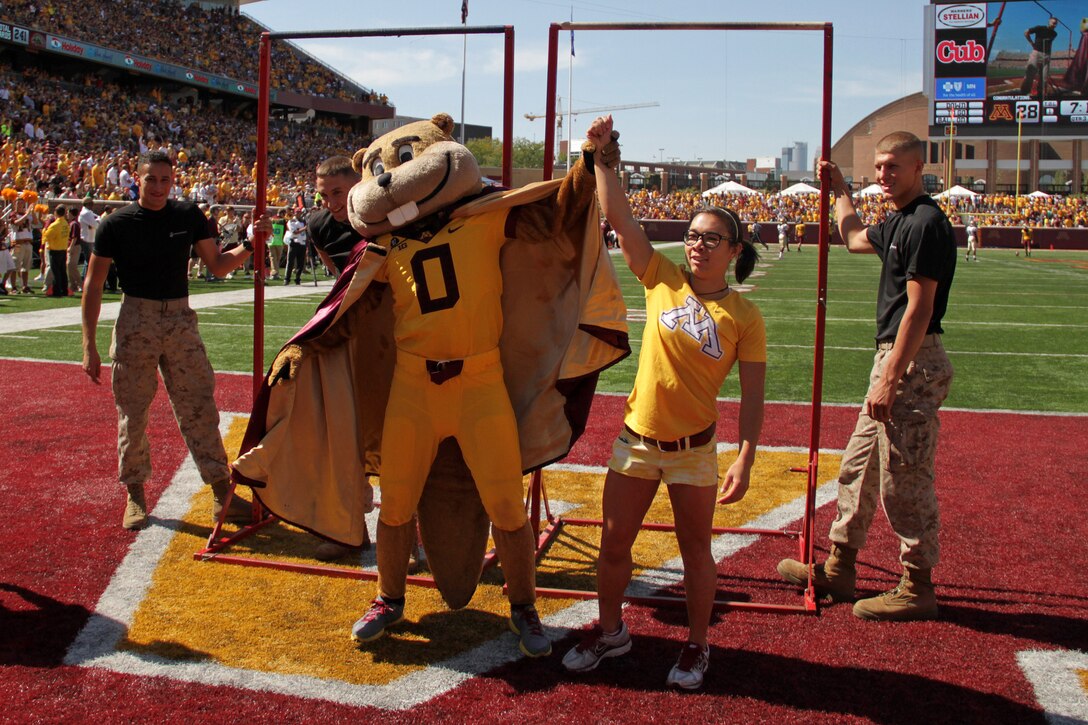 The University of Minnesota mascot, Goldy, declares gymnast Justine Cherwink the winner of a pull-up competition with Officer Selection Station Twin Cities' 1st Lt. Andrew Schroers  at TCF Bank Stadium during the military appreciation football game on Sept. 15. The announcer said Cherwink completed 33 dead-hang pull-ups compared to Schroers' 25. Both participants had 30 seconds to knock out as many as possible without kipping. For additional imagery from the event, visit www.facebook.com/rstwincities.