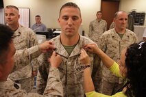 Administration chief Gunnery Sgt. Derald Lee and Maria Sughroue promote Seth Sughroue to the rank of sergeant on Aug. 1. Sughroue is an admin clerk with Recruiting Station Twin Cities.