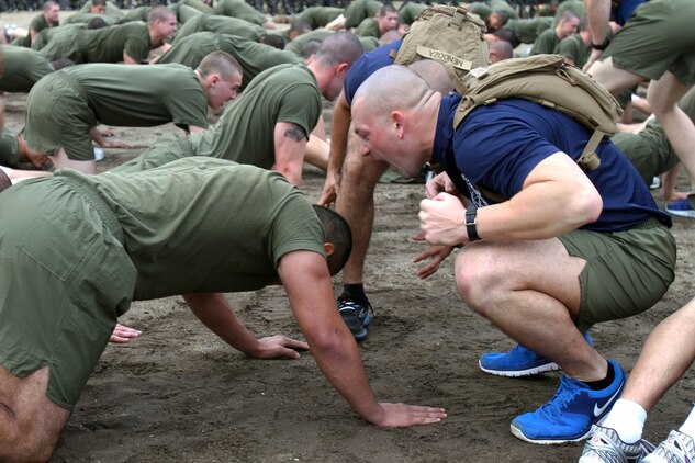 A recruit of Company K, 3rd Recruit Training Battalion, creates a choatoic environment as he motivates a recruit to push through the pain during warm-up exercises aboard Marine Corps Recruit Depot San Diego Dec. 18. Before recruits ran sprint intervls, they conducted several warm-up exercises to begin their physical training.