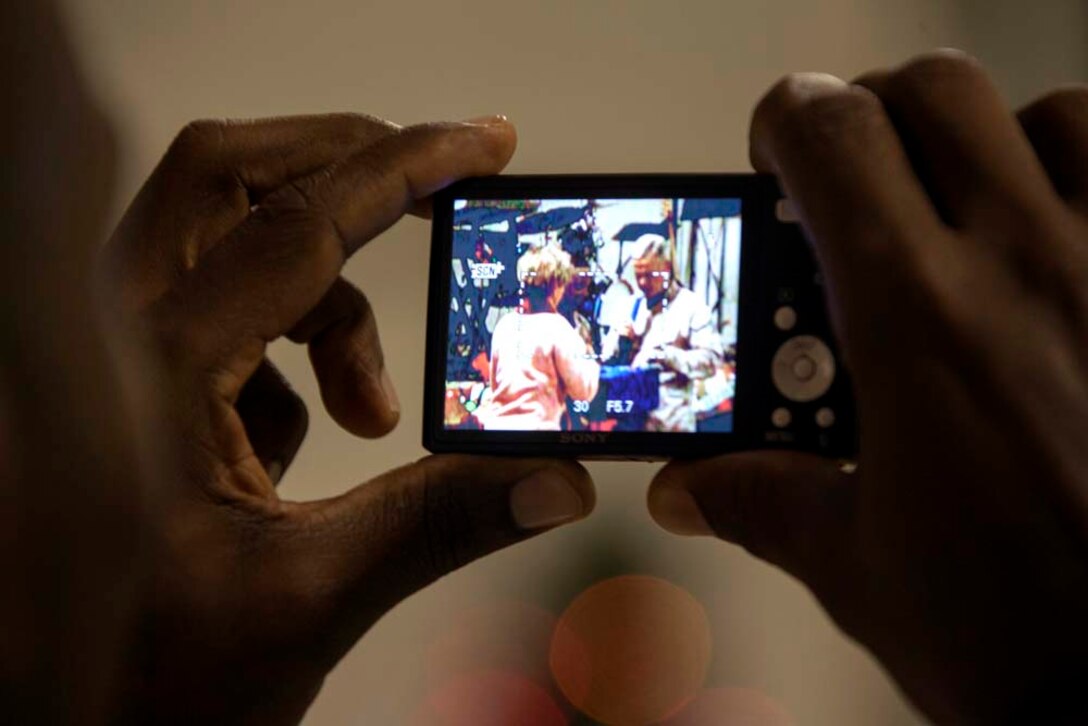 A U.S. Marine takes a picture of Commandant of the Marine Corps, Gen. James F. Amos and wife Bonnie Amos, during a Christmas Eve extravaganza on Camp Leatherneck, Helmand province, Afghanistan, Dec. 24, 2012. Gen. Amos and wife Bonnie spent the holidays visiting service members currently deployed to Afghanistan in support of Operation Enduring Freedom. (U.S. Marine Corps photo by SSgt. Ezekiel R. Kitandwe/Released)