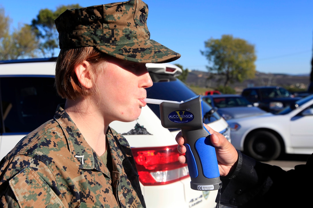 LCpl. Hazel Watson, a military policeman with Security Battalion, blows into a breathalyzer during a demonstration here Jan. 3. The demonstration gives a visual example of the process that Marines and sailors throughout the Marine Corps will undergo in accordance with Marine Administrative Message 709/12.