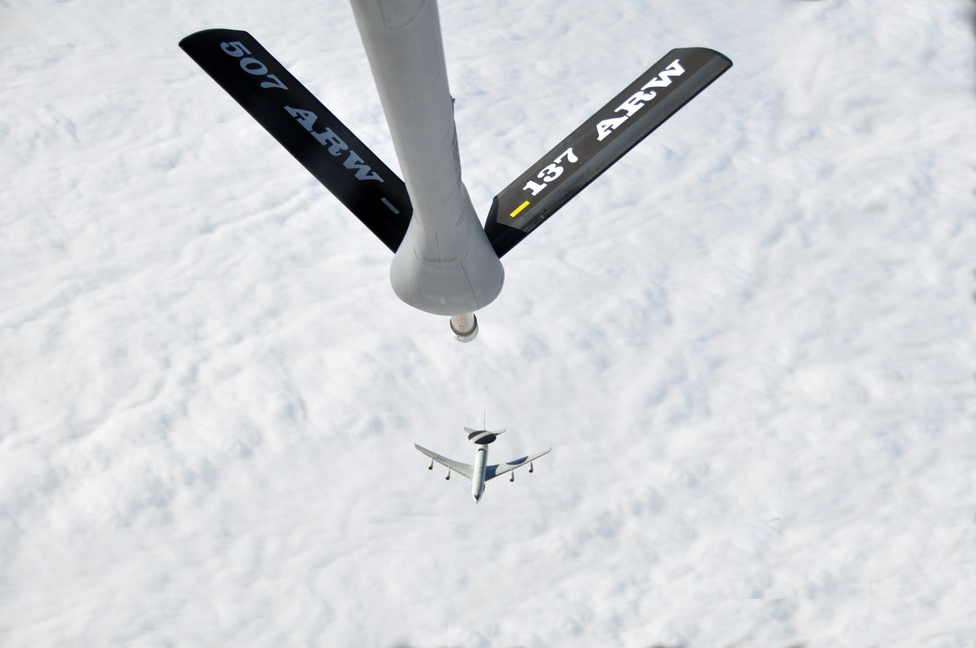 The boom on a 507th Air Refueling Wing’s KC-135 Stratotanker is at the ready as an E-3 Sentry from the 966th Airborne Air Control Squadron prepares to gain elevation in order to start an aerial refueling training mission over the cloudy skies of St. Louis.  