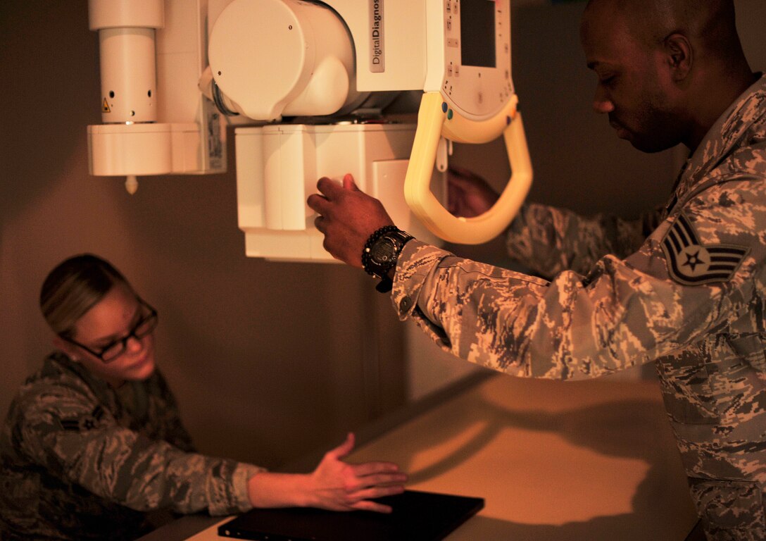 Staff Sgt. Anthony Francis and Airman 1st Class Rebecca Riccardi, 779th Medical Group Diagnostic Imaging Phase II students, simulate a hand X-Ray at the Malcolm Grow Medical Clinic, Dec. 19, 2012. To complete the course, the students endure five-months of Phase I training and seven-months of Phase II training. (U.S. Air Force photo/ Airman 1st Class Erin O’Shea) 