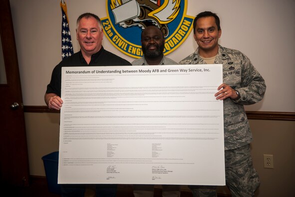Steve Quinn, Green Way Services general manager, Elvis Lane, 23d Civil Engineer Squadron base recycling program manager, and U.S. Air Force Lt. Col. Juan Alvarez, 23d CES commander, hold up a memorandum of understanding Dec. 18, 2012, at Moody Air Force Base, Ga. The 23d CES and Green Way Services negotiated an agreement for Moody to receive recycling services at no charge, saving $235,000 annually. The agreement helps prevent recyclables from going to landfills and allows Moody to do so at no cost. (U.S. Air Force photo by Airman Paul H. Francis/Released)
