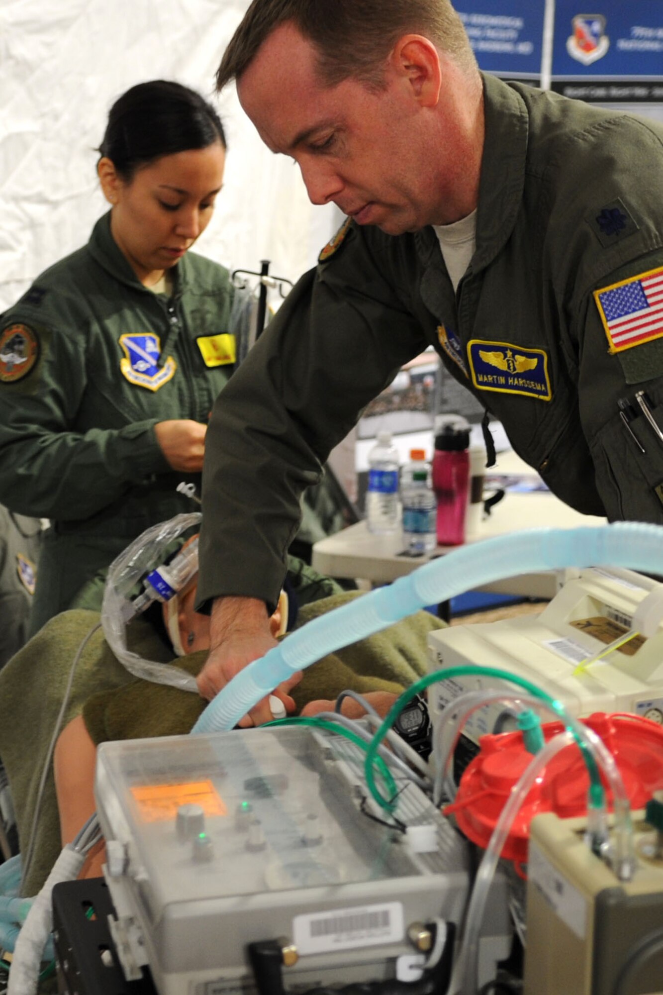 Lt. Col. (Dr.) Martin Harssema, Critical Care Air Transport Team medical director, and Capt. Amy Tomalavalge, CCATT coordinator, set up a display for the Military Village Expo  at the 2012 Military Bowl at RFK Stadium Dec. 27, in Washington, D.C. Both Harssema and Tomalavalge are members of the 779th Medical Group which is part of Air Force District of Washington located at Joint Base Andrews, Md. (U.S. Air Force photo by Tech. Sgt. Tammie Moore)