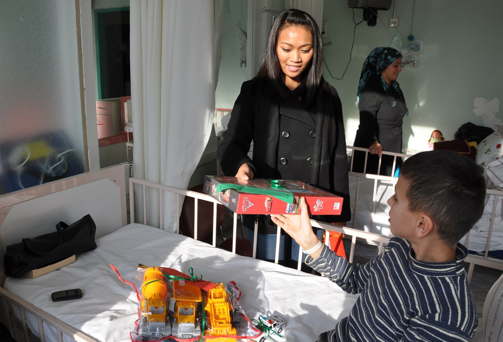 Senior Airman Alexandra San Joaquin, 425th Air Base Squadron client systems
technician, hands out a toy to a Turkish boy at an Izmir children's hospital
Dec. 21, 2012. (U.S. Air Force photo by Tanju Varlikli/Released)
