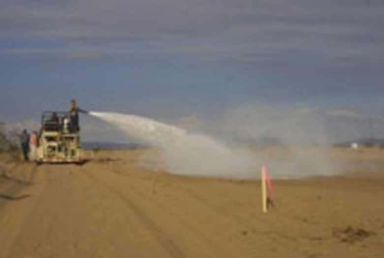 ERDC researchers use a hydroseeder to create a dust-free helicopter landing pad in Yuma, AZ.