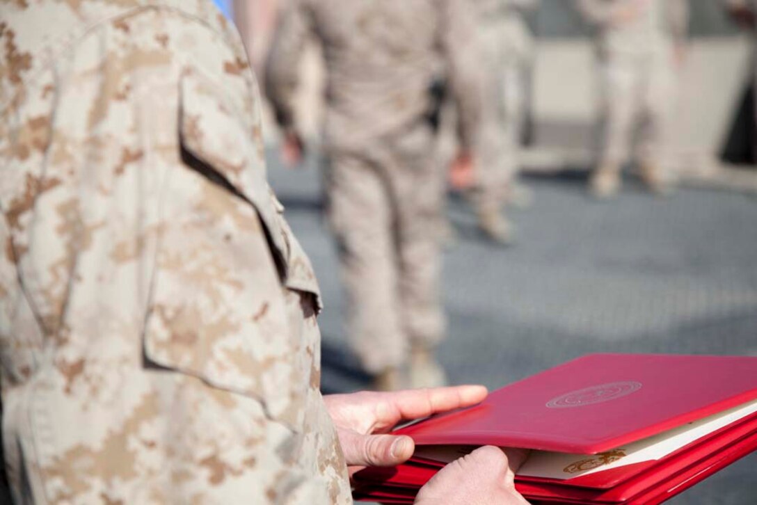 U.S. Marine Corps Gunnery Sgt. Jeremy W. Archer with Headquarters Company, Regimental Combat Team 7 (RCT-7), holds a reenlistment warrant on Camp Leatherneck, Helmand province, Afghanistan, Jan. 1, 2013. The Marines and Sailors with RCT-7 are currently deployed to Afghanistan in support of Operation Enduring Freedom. (U.S. Marine Corps photo by Staff Sgt. Ezekiel R. Kitandwe/Released)