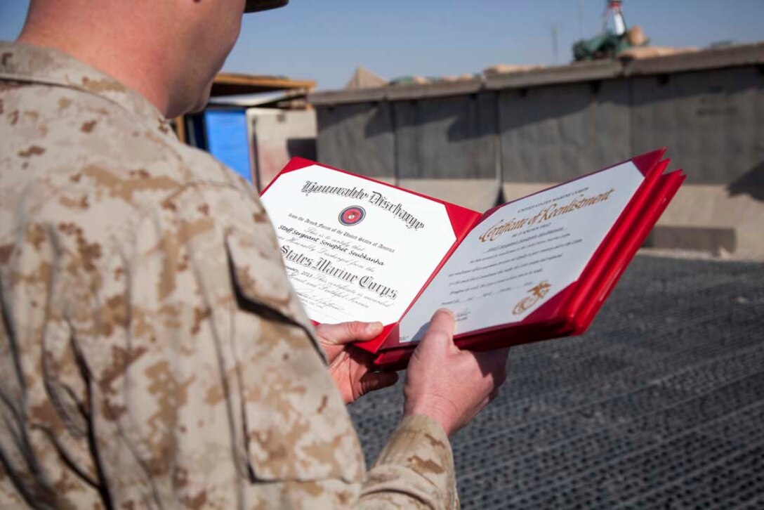 U.S. Marine Corps Gunnery Sgt. Jeremy W. Archer with Headquarters Company, Regimental Combat Team 7 (RCT-7), reads out a certificate of reenlistment for U.S. Marine Staff Sgt. Sonephet Seubkanha on Camp Leatherneck, Helmand province, Afghanistan, Jan. 1, 2013. Seubkanha is currently deployed to Afghanistan in support of Operation Enduring Freedom. (U.S. Marine Corps photo by Staff Sgt. Ezekiel R. Kitandwe/Released)