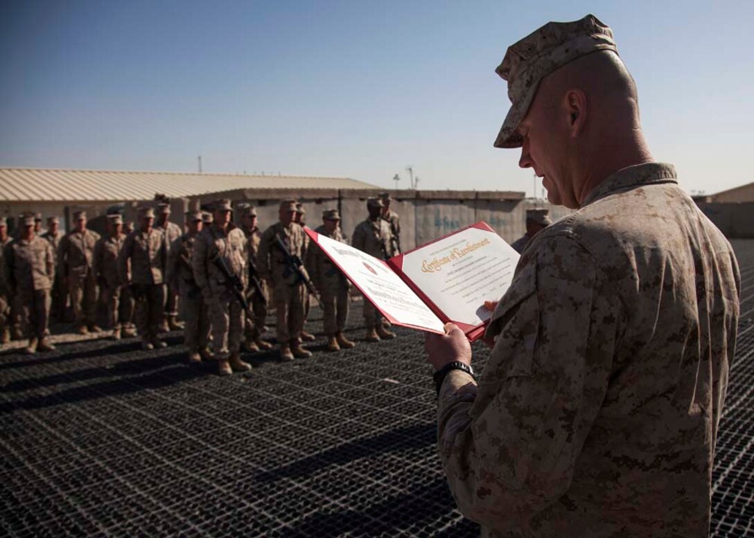 U.S. Marine Corps Gunnery Sgt. Jeremy W. Archer with Headquarters Company, Regimental Combat Team 7 (RCT-7), reads out a certificate of reenlistment for U.S. Marine Staff Sgt. Sonephet Seubkanha on Camp Leatherneck, Helmand province, Afghanistan, Jan. 1, 2013. Seubkanha is currently deployed to Afghanistan in support of Operation Enduring Freedom. (U.S. Marine Corps photo by Staff Sgt. Ezekiel R. Kitandwe/Released)