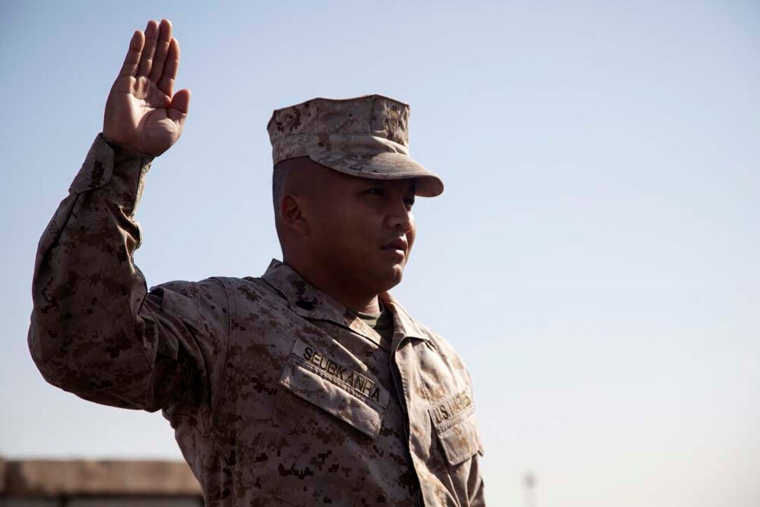 U.S. Marine Corps Staff Sgt. Sonephet Seubkanha, center, with Headquarters Company, Regimental Combat Team 7 (RCT-7), recites the Oath of Enlistment during his reenlistment ceremony on Camp Leatherneck, Helmand province, Afghanistan, Jan. 1, 2013. Seubkanha is currently deployed to Afghanistan in support of Operation Enduring Freedom. (U.S. Marine Corps photo by Staff Sgt. Ezekiel R. Kitandwe/Released)