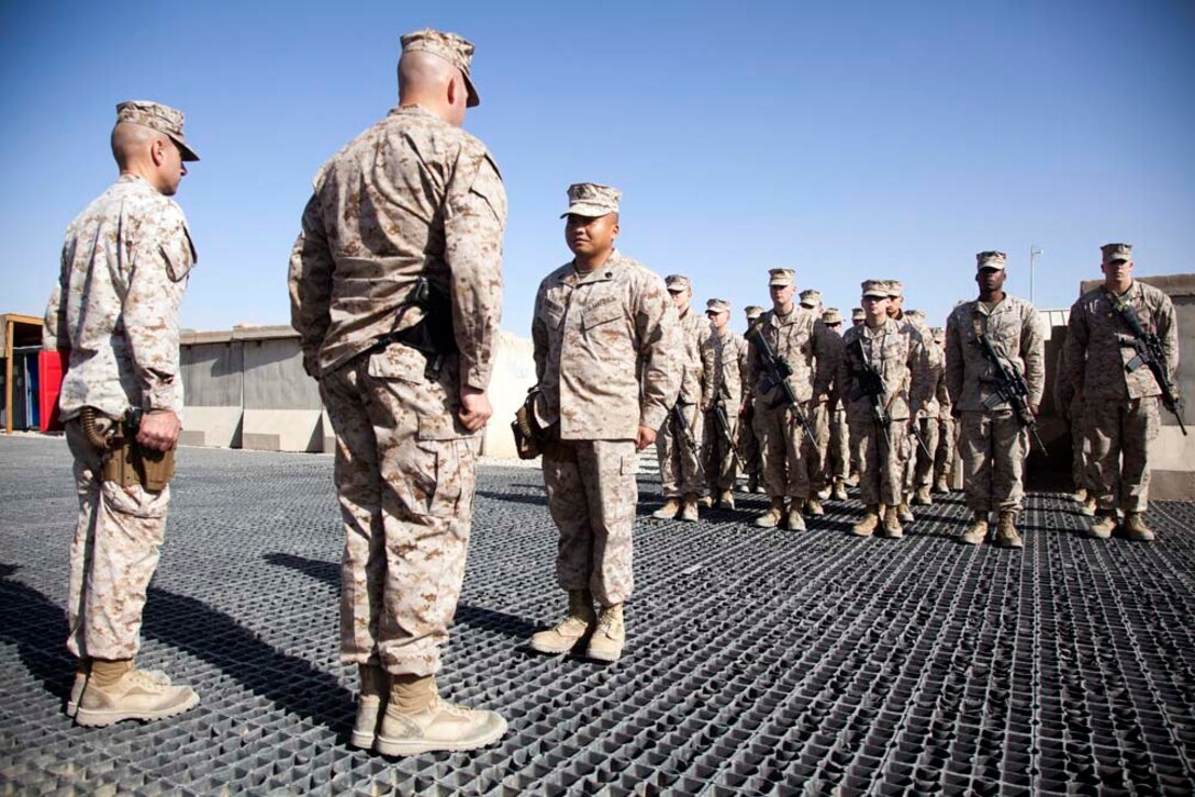 U.S. Marine Corps Staff Sgt. Sonephet Seubkanha, center, with Headquarters Company, Regimental Combat Team 7 (RCT-7), stands at attention during his reenlistment ceremony on Camp Leatherneck, Helmand province, Afghanistan, Jan. 1, 2013.Seubkanha is currently deployed to Afghanistan in support of Operation Enduring Freedom. (U.S. Marine Corps photo by Staff Sgt. Ezekiel R. Kitandwe/Released)