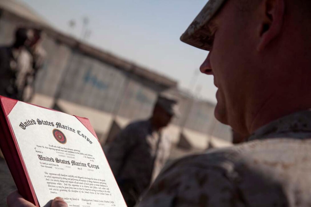 U.S. Marine Corps Gunnery Sgt. Jeremy W. Archer with Headquarters Company, Regimental Combat Team 7 (RCT-7), reads out a promotion warrant during a promotion ceremony held for U.S. Marine Staff Sgt. Sonephet Seubkanha on Camp Leatherneck, Helmand province, Afghanistan, Jan. 1, 2013. Seubkanha was being promoted to his current rank of Gunnery Sgt. shortly after reenlisting for another years. (U.S. Marine Corps photo by Staff Sgt. Ezekiel R. Kitandwe/Released)
