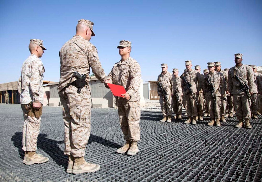 U.S. Marine Corps Staff Sgt. Robert J. Bell, center, with Headquarters Company, Regimental Combat Team 7 (RCT-7), accepts his promotion warrant on Camp Leatherneck, Helmand province, Afghanistan, Jan. 1, 2013. Bell is currently deployed to Afghanistan in support of Operation Enduring Freedom. (U.S. Marine Corps photo by Staff Sgt. Ezekiel R. Kitandwe/Released)