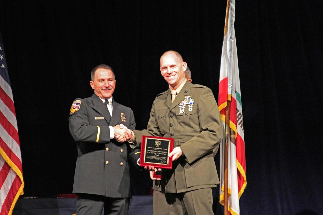 Lt. Col. William Hooper, 3rd Marine Air Wing Deputy Operations Officer, accepts the 2012 Cal Fire Director's Partnership Award on behalf of the 1st Marine Expeditionary Force from Chief Ken Pimlott, California Department of Forestry & Fire Protection Director at a ceremony in Sacramento, Calif., Jan. 3. The unit was selected for the award based on its supporting stance in times of dire need from Cal Fire services. Marine Corps Installations West also received the same award, and each was recognized for supplying both aerial and ground equipment in support of fire suppression efforts.

"Marines are part of the community in Southern California, and we're proud to be able to provide resources when needed to protect the lives and property of our neighbors," Hooper said.


