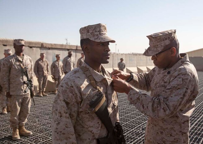 U.S. Marine Corps  U.S. Marine Lance Cpl. Michael J. Garner, center, with Headquarters Company, Regimental Combat Team 7 (RCT-7), is promoted to the rank of Cpl. on Camp Leatherneck, Helmand province, Afghanistan, Jan. 1, 2013. Garner is currently deployed to Afghanistan in support of Operation Enduring Freedom. (U.S. Marine Corps photo by Staff Sgt. Ezekiel R. Kitandwe/Released)