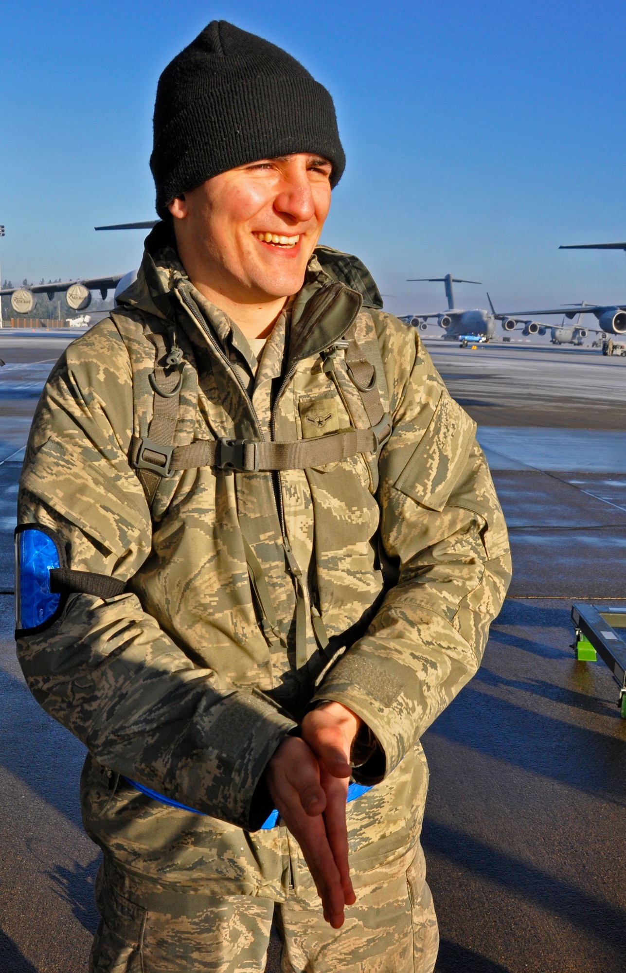 Airman Samuel Guest, a crew chief with the 446th Aircraft Maintenance Squadron, rubs his hands together for warmth Jan. 3, a day with a low of 19 degrees Farenheit, on McChord Field, Wash. Maintainers like Guest have to find creative ways to stay warm in the winter months while working out on the flightline. (U.S. Air Force Photo/Staff Sgt. Rachael Garneau)