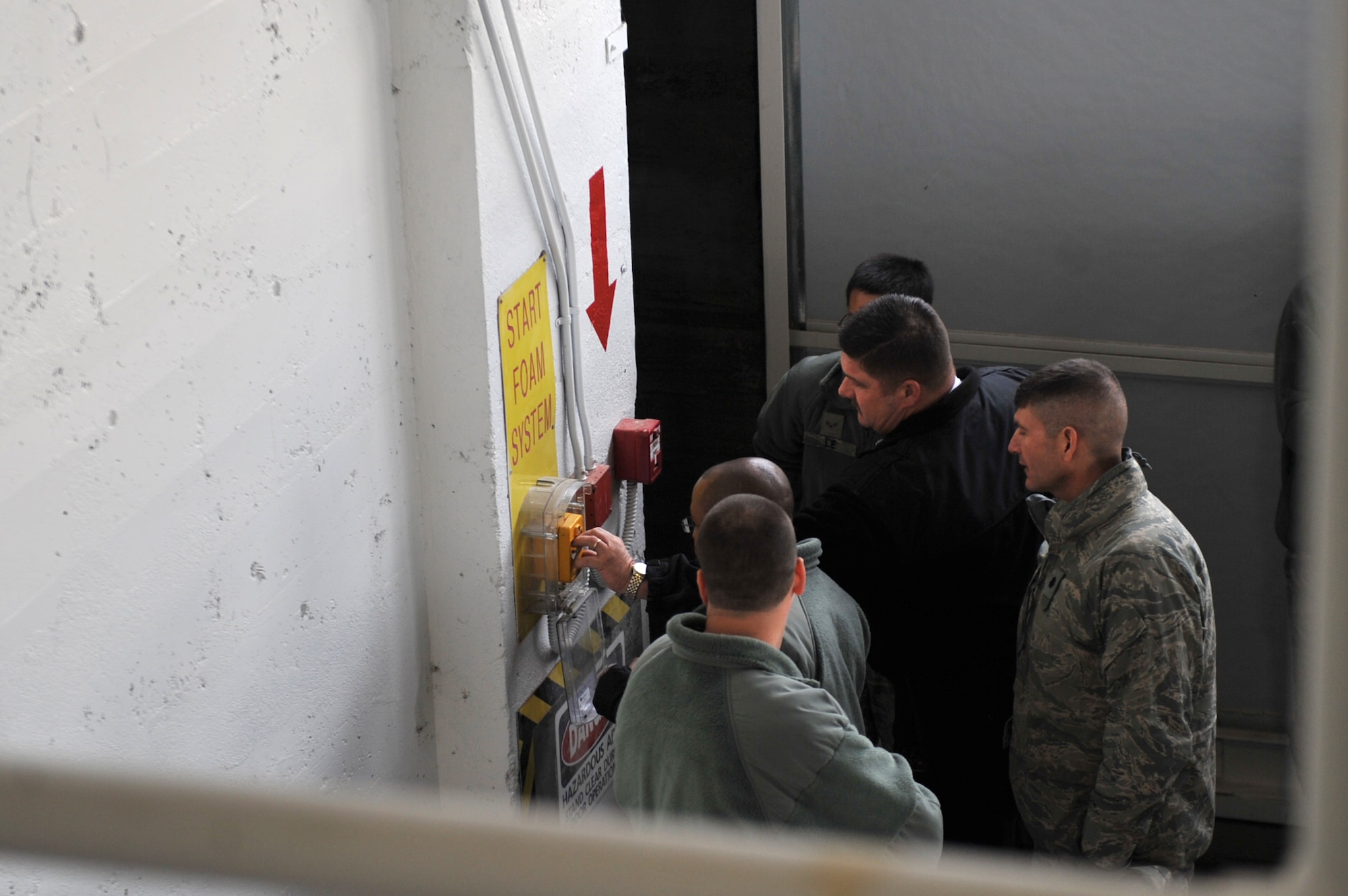 U.S. Air Force Airmen watch while Hangar 211’s foam fire suppression system handle is pulled Dec. 21, 2012, at Mountain Home Air Force Base, Idaho. The foam is dispensed from ceiling generators while Airmen assigned to the 366th Civil Engineering Squadron checked for proper foam expansion. (U.S. Air Force photo/Senior Airman Heather Hayward)