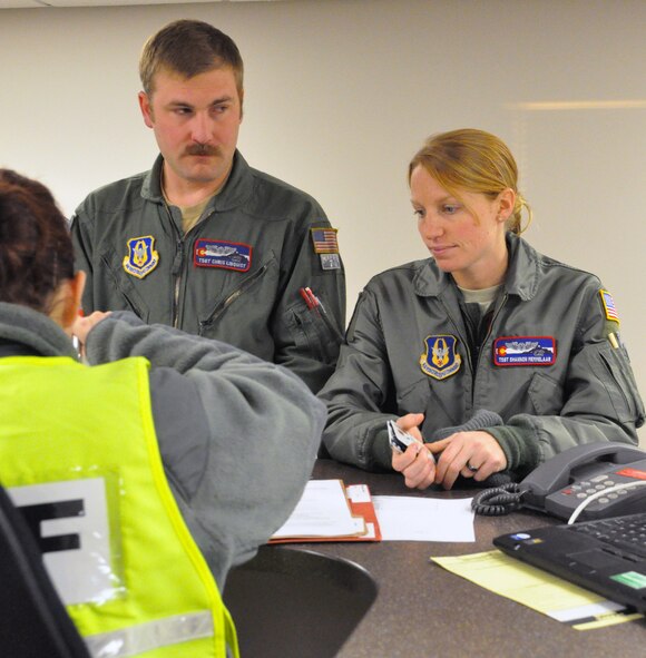 PETERSON AIR FORCE BASE, Colo. Tech. Sgts. Chris Linquist, left, and Shannon Memmelaar, process through the personnel deployment function line Dec. 21 here. The Air Force Reserve Command’s 302nd Airlift Wing sent personnel and aircraft to Puerto Rico's Muniz Air National Guard Base in support of Operation Coronet Oak. There they will support U.S. Southern Command with logistics and contingency efforts. The operation encompasses several missions, including resupply of U.S. embassies, medical evacuation and support for U.S. troops in the region. Linquist and Memmelaar are loadmasters for the 731st Airlift Squadron. (U.S. Air Force photo/Tech Sgt. Daniel Butterfield)