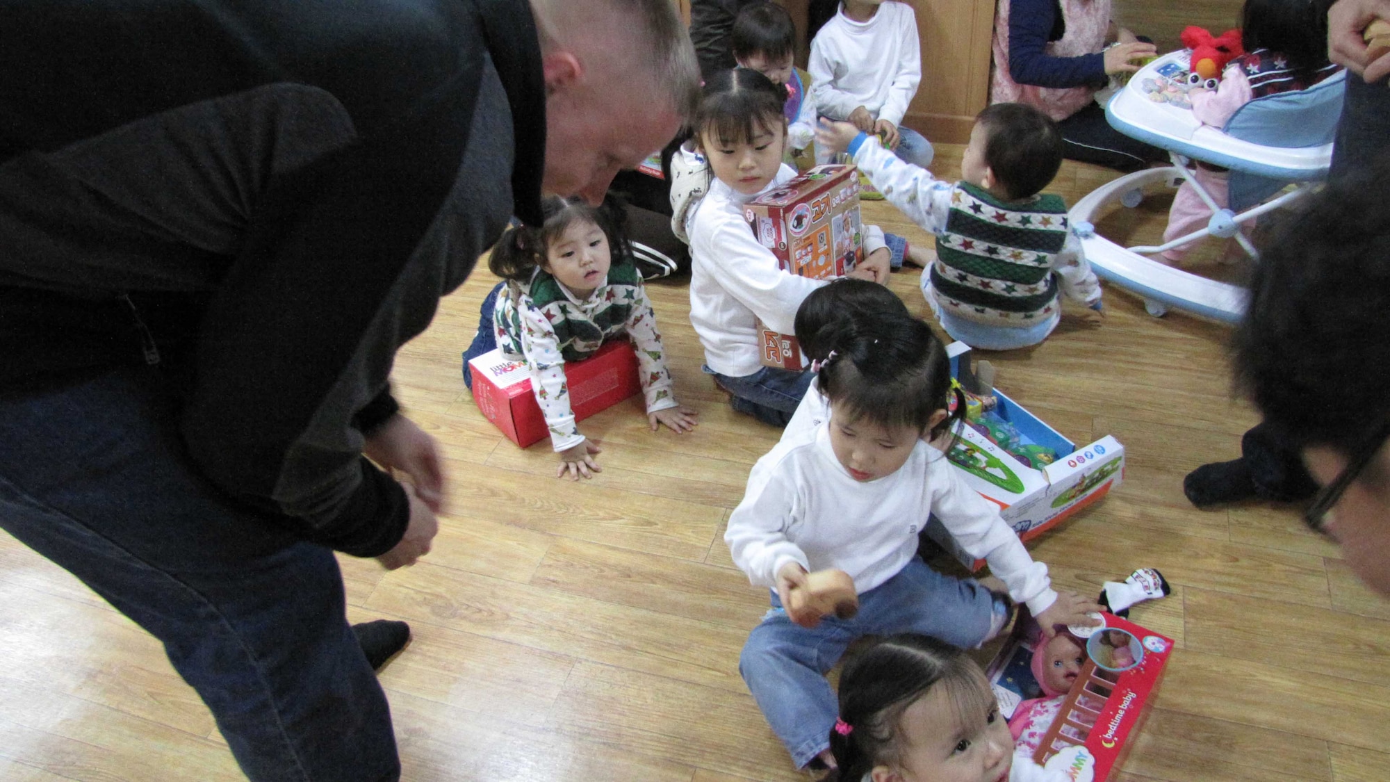 A member of the Air Force Technical Applications Center's Detachment 452 presents a hand-carved wooden car to a little girl at the Chechon Children's Home, an orphanage near Wonju, S. Korea.  The cars were a gift from Ed Wares, father of Sabrina Miller, AFTAC's Scientific & Technical Information Program Manager.  Members of the detachment visited the facility Dec. 22. 2012 to distribute gifts to the children.  “When we get to do outreach like this, especially for children, it really brings things into a greater perspective for me personally,” said Senior Master Sgt. Wesley Schuler, Det. 452 chief. “It also makes me realize how incredibly generous Airmen and my fellow American citizens are to take the time and effort to donate to this great cause. It’s very moving to see the faces of these children just light up when they’re each given a personal gift.” (Courtesy photo)