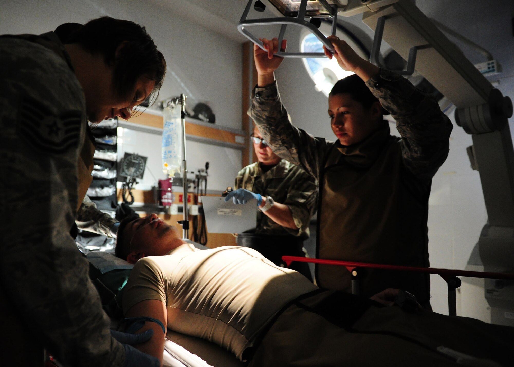 SOUTHWEST ASIA – (right) Staff Sgt. Charlie Gess, 379th Expeditionary Medical Group diagnostic imaging technologist, zooms in with a portable X-ray unit arm to perform a chest X-ray on an unconscious patient. Portable X-ray units are extremely valuable when time is critical and medics are unable to move the patient. Gess is deployed from Wright-Patterson Air Force Base, Ohio. (U.S. Air Force photo/Master Sgt. Brendan Kavanaugh)
