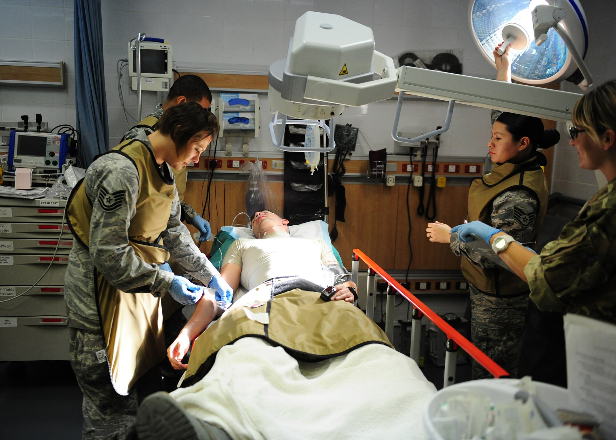 SOUTHWEST ASIA - 379th Expeditionary Medical Group diagnostics team members position a portable X-ray unit over an unconscious patient. During an emergency, every member of the team plays a vital role in rapid evaluation, diagnosis and treatment of the patient. (U.S. Air Force photo/Master Sgt. Brendan Kavanaugh)