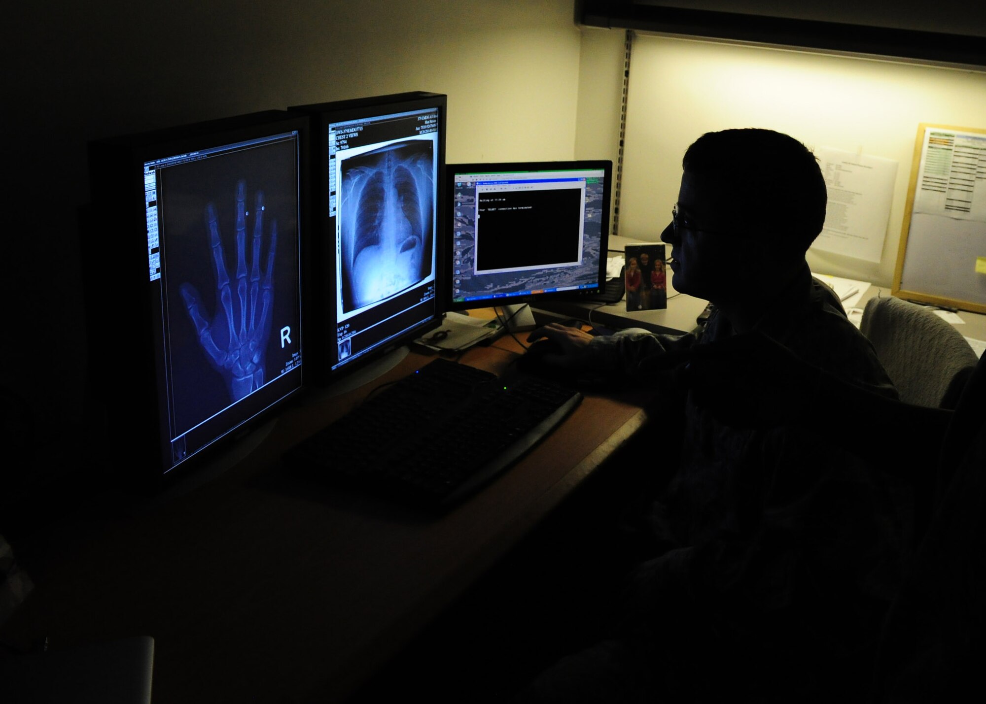 SOUTHWEST ASIA - Maj. (Dr.) Douglas Vanderkooi, 379th Expeditionary Medical Group radiologist, examines digital images of a hand for fractures and a chest x-ray for possible abnormalities. Dr. Vanderkooi is deployed from Langley Air Force Base, Va. (U.S. Air Force photo/Master Sgt. Brendan Kavanaugh)
