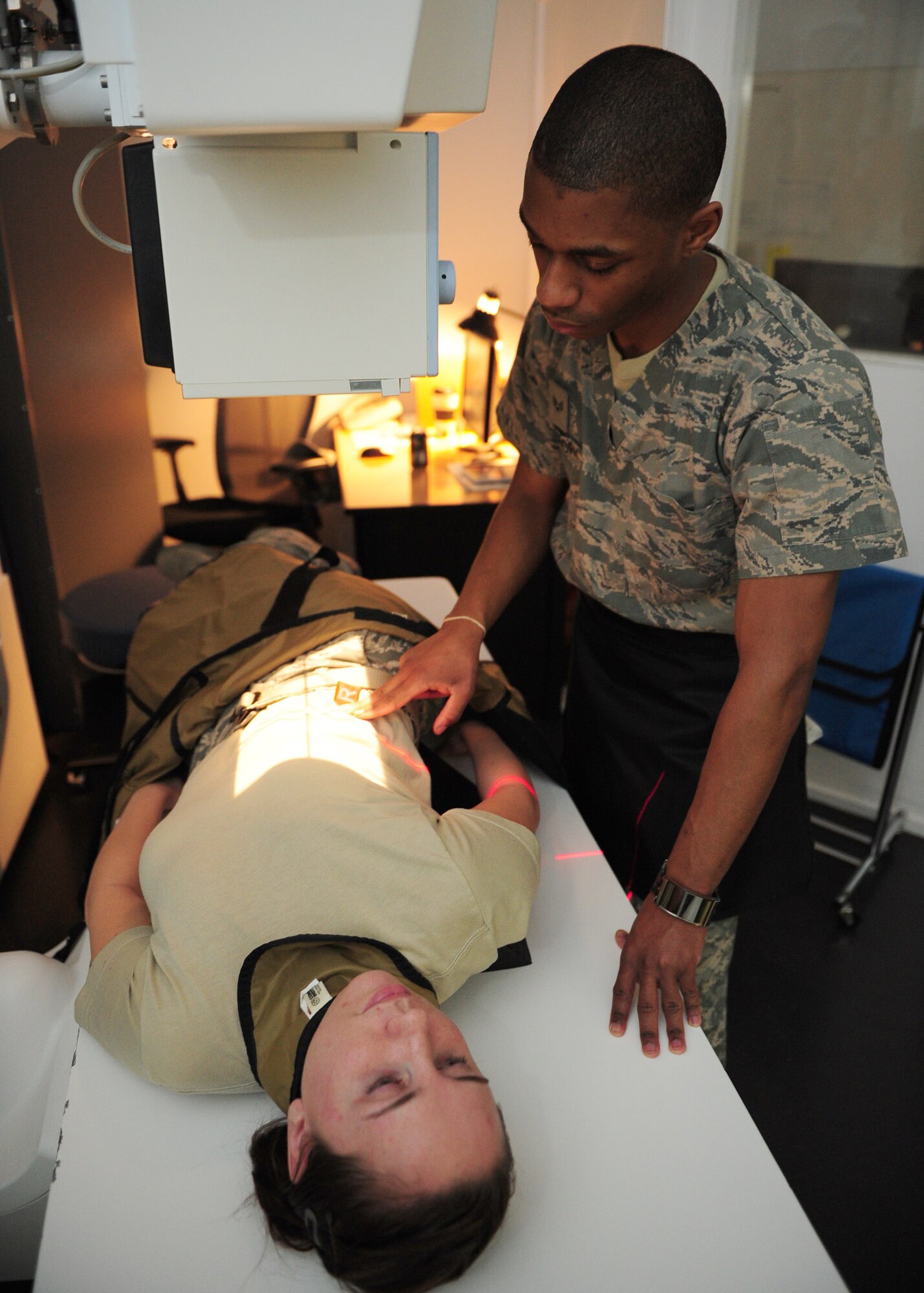 SOUTHWEST ASIA – Senior Airman Edward McCrory, 379th Expeditionary Medical Group diagnostic imaging technologist, positions a patient for a spinal x-ray. Personnel in this career field undergo a minimum of 16 months of training before being qualified to perform duties in a deployed location. McCrory is a native of Atlanta, Ga., and is deployed from Langley Air Force Base, Va. (U.S. Air Force photo/Master Sgt. Brendan Kavanaugh)