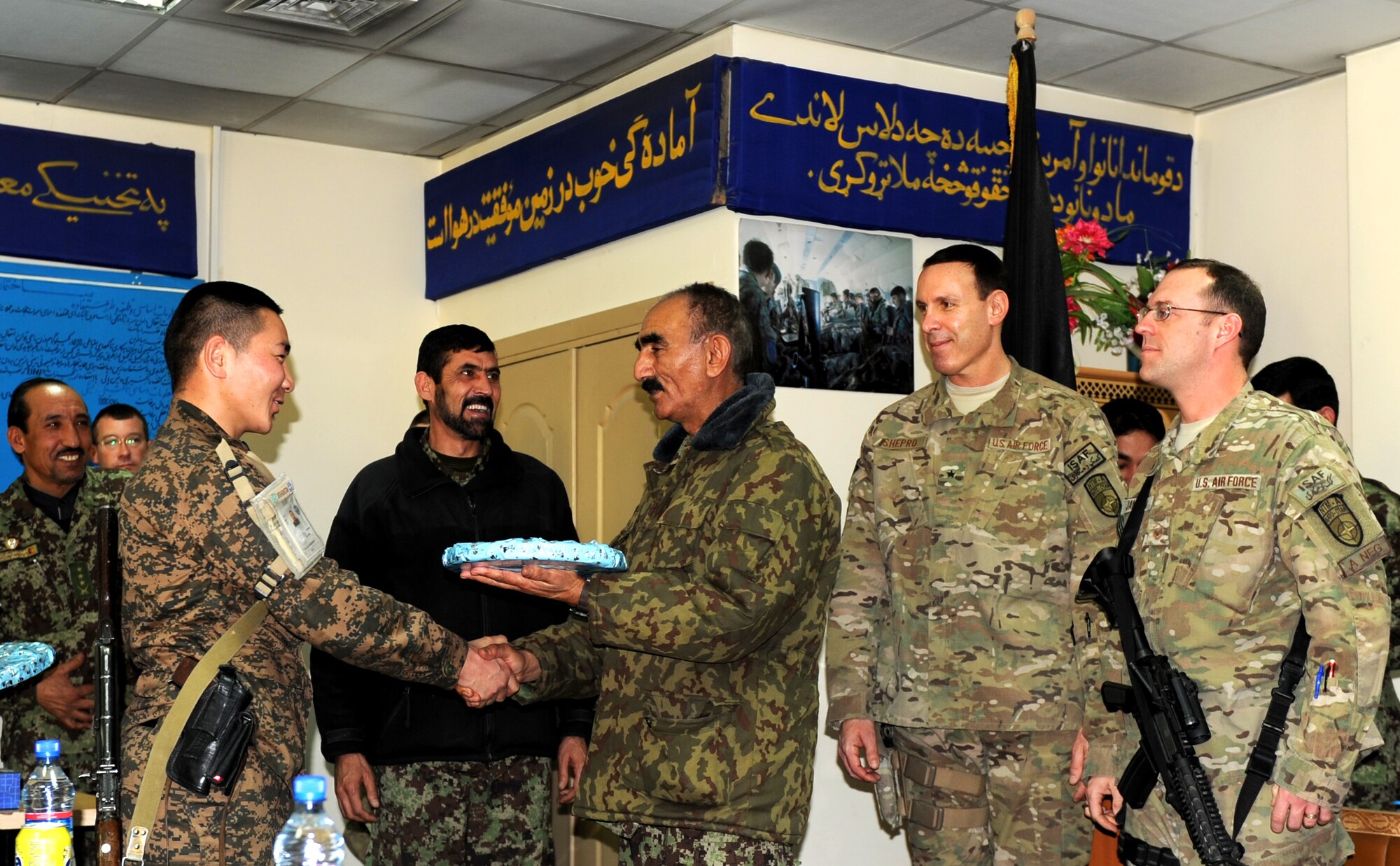Afghan Air Force Col. Mahmood Rahman (center), commander of Afghanistan’s Air University  ‘Pohantoon-e-Hayayee’ presents Mongolian Air Force First Lt. Dorjderem Baatar, instructor for the Mongolian Air Force Mentoring Team, with a gift of appreciation for his hard work as an advisor Dec. 20, 2012. A graduation ceremony was held the same day for 16 Afghan Air Force students who successfully completed an eleven week Mi-17 helicopter ‘Engine & Body’ course.  (U.S. Air Force photo/Staff Sgt. Mekpongsatorn)