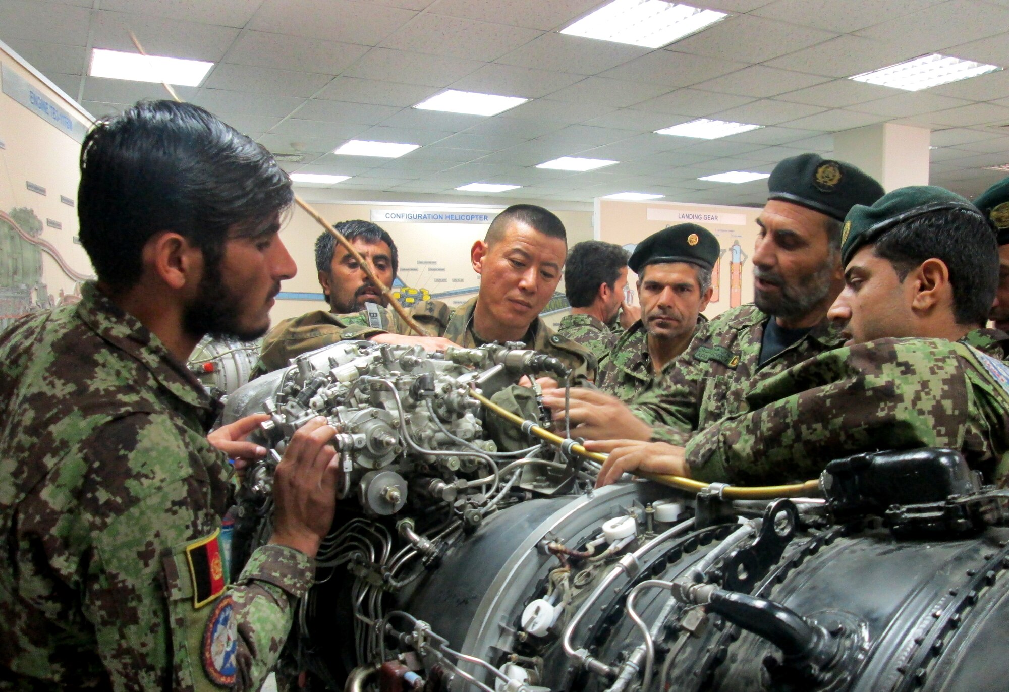 Afghan Air Force maintenance instructors and students gather around an Mi-17 engine in a classroom at the Kabul, Afghanistan, International Airport, Nov. 14, 2012, assisted by Mongolian Air Force Mentoring Team Advisor Lt. Enkh-amgalan Sosorbaram (center), on his second deployment to the NATO Air Training mission. The Afghan AF’s newest 16 Mi-17 helicopter technicians crossed a stage Dec. 20, 2012 at the airport, receiving certificates from Afghan AF leaders, Mongolian advisors, and 438th Expeditionary Wing leadership. (Courtesy photo) 