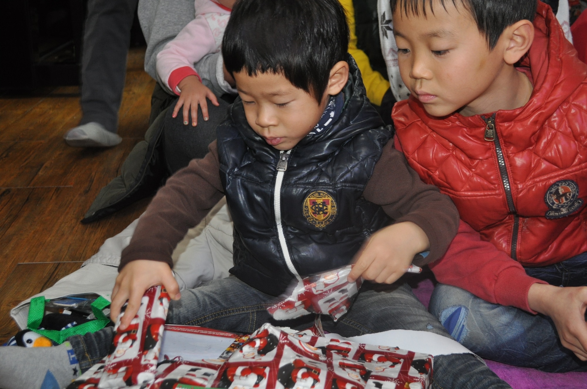 Children from the Ae Hyang Child Welfare Center open presents given to them by members of the 36th Fighter Squadron on a visit to the orphanage in Pyeontaek Dec. 15, 2012. The more than 75 members delivered Christmas cheer in the form of gifts and homemade traditional American sweets. (courtesy photo)