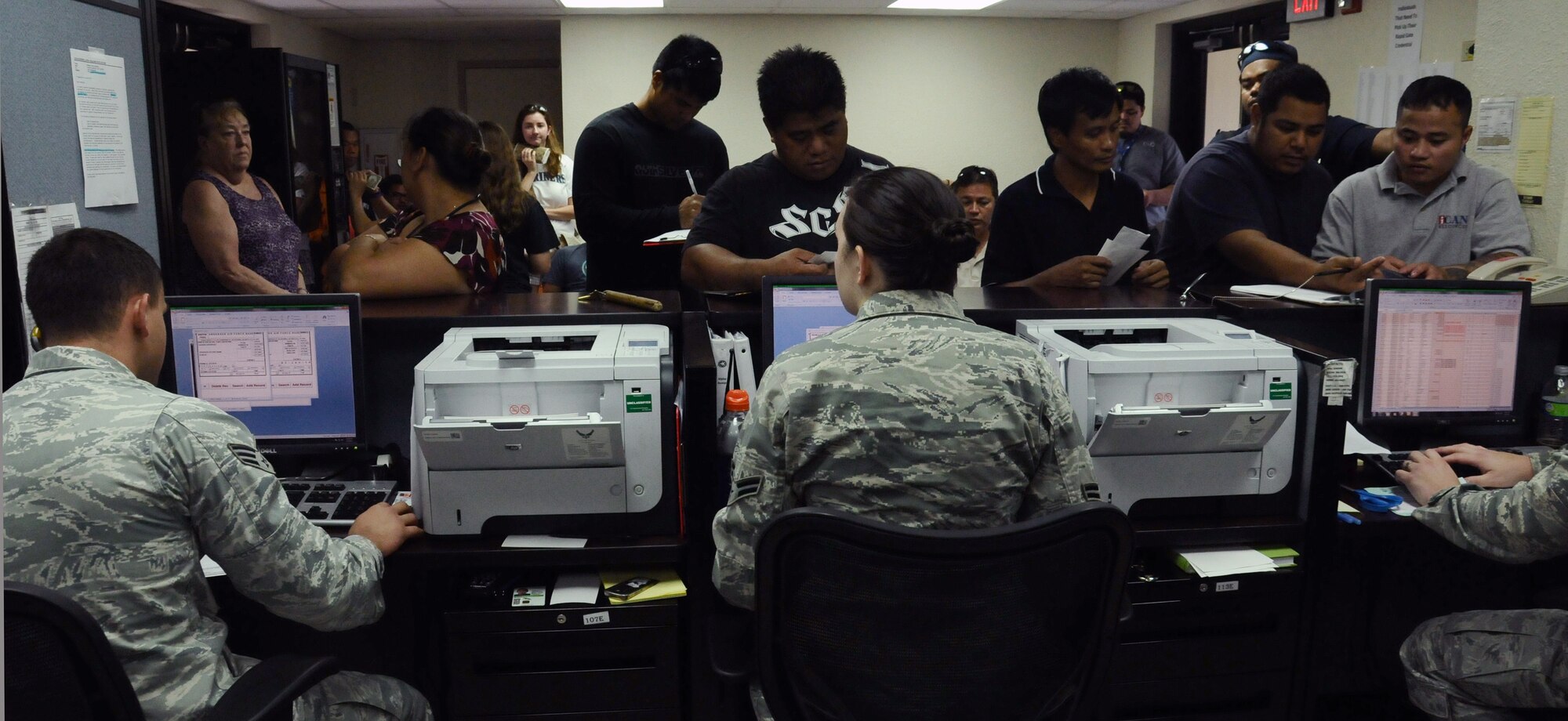 Senior Airman Aaron Rustici and Airman 1st Class Randi Hormig, pass and registration clerks from the 36th Security Forces Squadron, assist customers at the Visitor Control Center at Andersen Air Force Base, Guam, Jan. 2, 2013. The VCC services from 200 to 300 customers a day. ( U.S. Air Force photo by Airman 1st Class Mariah Haddenham/Released)