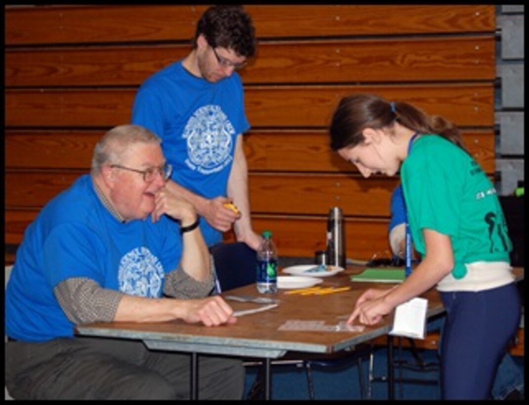 Dr. Harold Balbach, left, and Chandler Armstrong give an academic challenge to a student competing in the Pentathlon event.  
