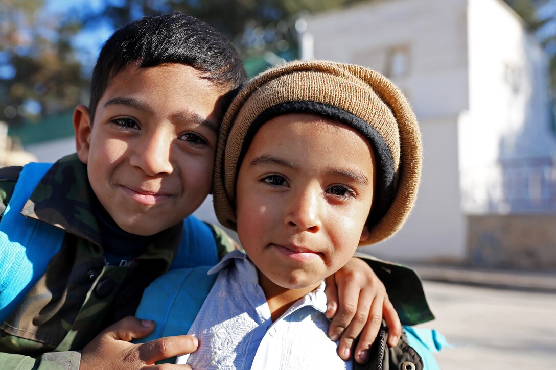 Two Afghan boys pose for a photo outside a meeting with leaders in Farah City, Afghanistan, Jan. 3, 2013.