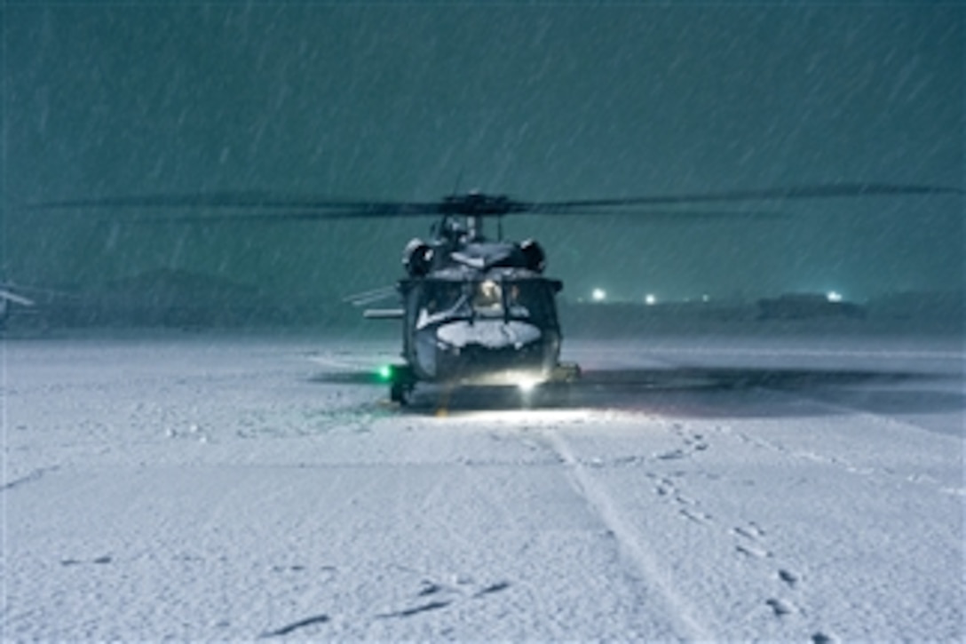 A U.S. Army UH-60 Black Hawk helicopter with Alpha Company, 5th Battalion, 101st Combat Aviation Brigade conducts an engine run-up in the falling snow of a winter storm at Bagram Airfield in the Parwan province of Afghanistan on Dec. 27, 2012.  