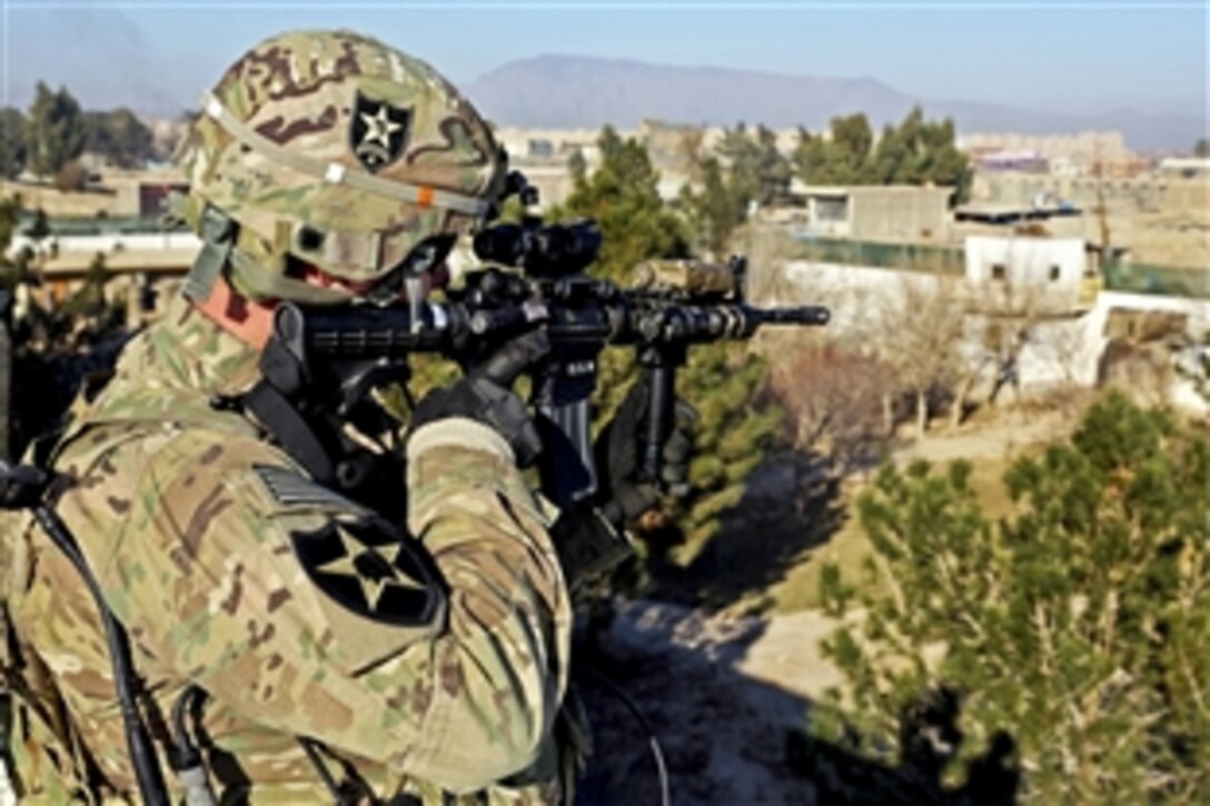 From the rooftop at the site of a meeting with provincial leaders, U.S. Army 1st Lt. Ryan Schulte uses his weapon's optic lens to scan for security threats in Farah City, Afghanistan, Jan. 3, 2013. Schulte is assigned to Provincial Reconstruction Team Farah.