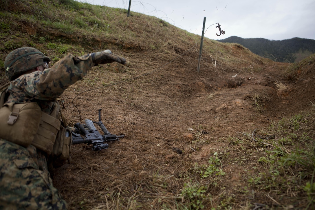 A Marine with Battalion Landing Team 1st Battalion, 5th Marine Regiment, 31st Marine Expeditionary Unit, throws a makeshift grappling hook at a concertina wire barrier during a live-fire exercise here, Jan 4. The Marines and Sailors of BLT 1/5 conducted this training to hone their combat skills in a jungle environment. The 31st MEU is the only continuously forward-deployed MEU and is the Marine Corps’ force in readiness in the Asia-Pacific region.