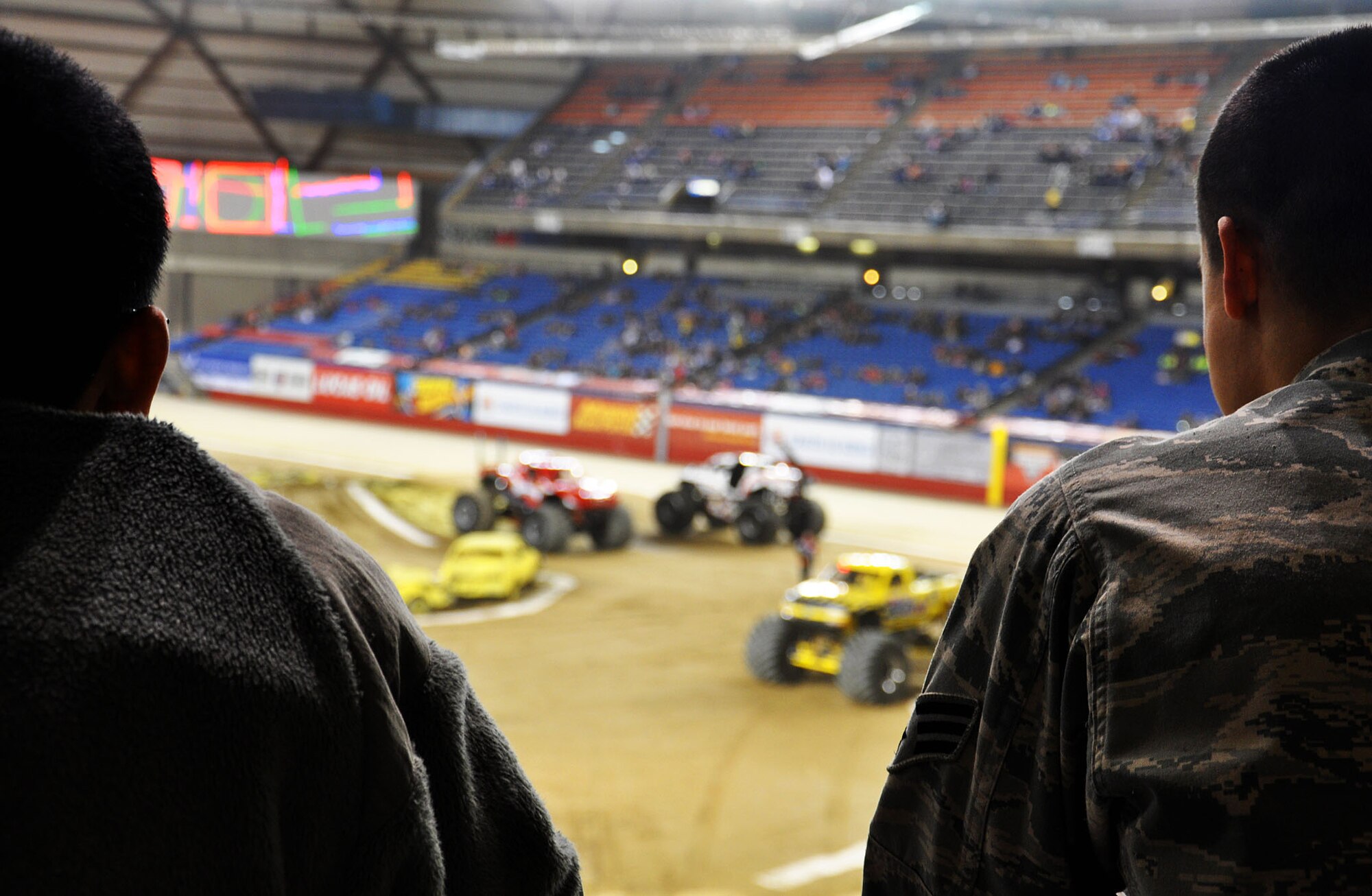 Senior Airman Marciano Quinonez-Cheeks and Senior Airman Justin Drayer, crew chiefs with the 446th aircraft maintenance squadron, watch the trucks at Monster Jam at the Tacoma Dome Jan. 5, 2013. These two airmen spent the day telling civilians about their jobs as crew chiefs and what they can expect from a life in the Air Force Reserves. (U.S. Air Force Photo/Airman 1st Class Madelyn McCullough)