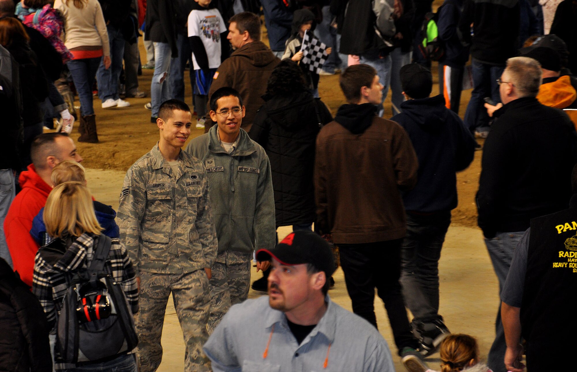 Senior Airman Justin Drayer and Senior Airman Marciana Quinonez-Cheeks, crew chiefs with the 446th aircraft maintenance squadron, walk through the Monster Jam pit party at the Tacoma Dome Jan. 5, 2013. These airmen were specifically chosen by their units for outstanding performance and accepted the opportunity to help recruiters spread the message of the Air Force Reserve. (U.S. Air Force Photo/Airman 1st Class Madelyn McCullough)