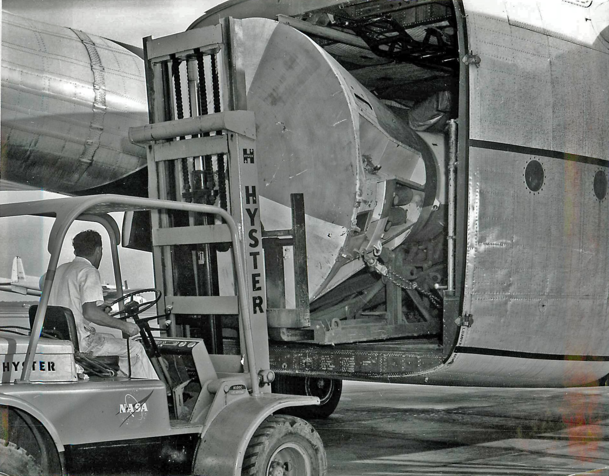 An Ellington Air Force Base, Texas, aircrew member loads a Mercury boilerplate capsule onto a C-119J "Flying Boxcar" in 1962. The 446th Airlift Wing was based out of Ellington when it began as the 446th Troop Carrier Wing in 1955. The unit began working with NASA in 1961. (Courtesy Photo)