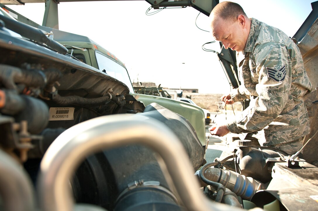 SSgt. Justin Davis checks the oil on a truck at the 189th vehicle ops building.