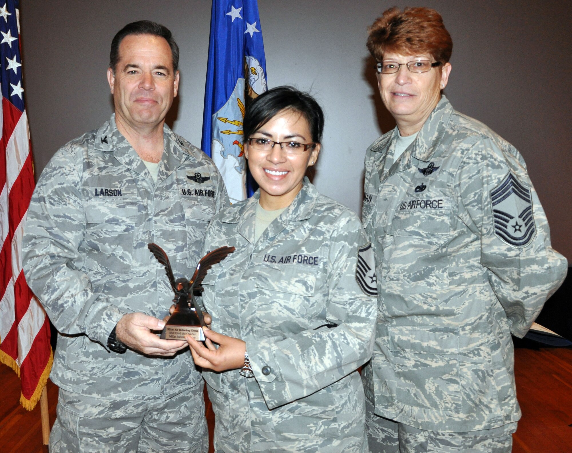 Col. Mark S. Larson, commander of the 931st Air Refueling Group, and Chief Master Sgt. Kathleen E. Lowman, 931st Air Refueling Group superintendent, present the Senior Noncommissioned Officer of the Quarter for the 4th quarter of 2012 award to Master Sgt. Marina Coronado during the 931st Air Refueling Group commander's call at McConnell Air Force Base, Kan, Jan. 6, 2013.  Coronado accepted the award on behalf of Master Sgt. Steven Tracy who was unable to attend the ceremony.  (U.S. Air Force photo by 1st Lt. Zach Anderson)