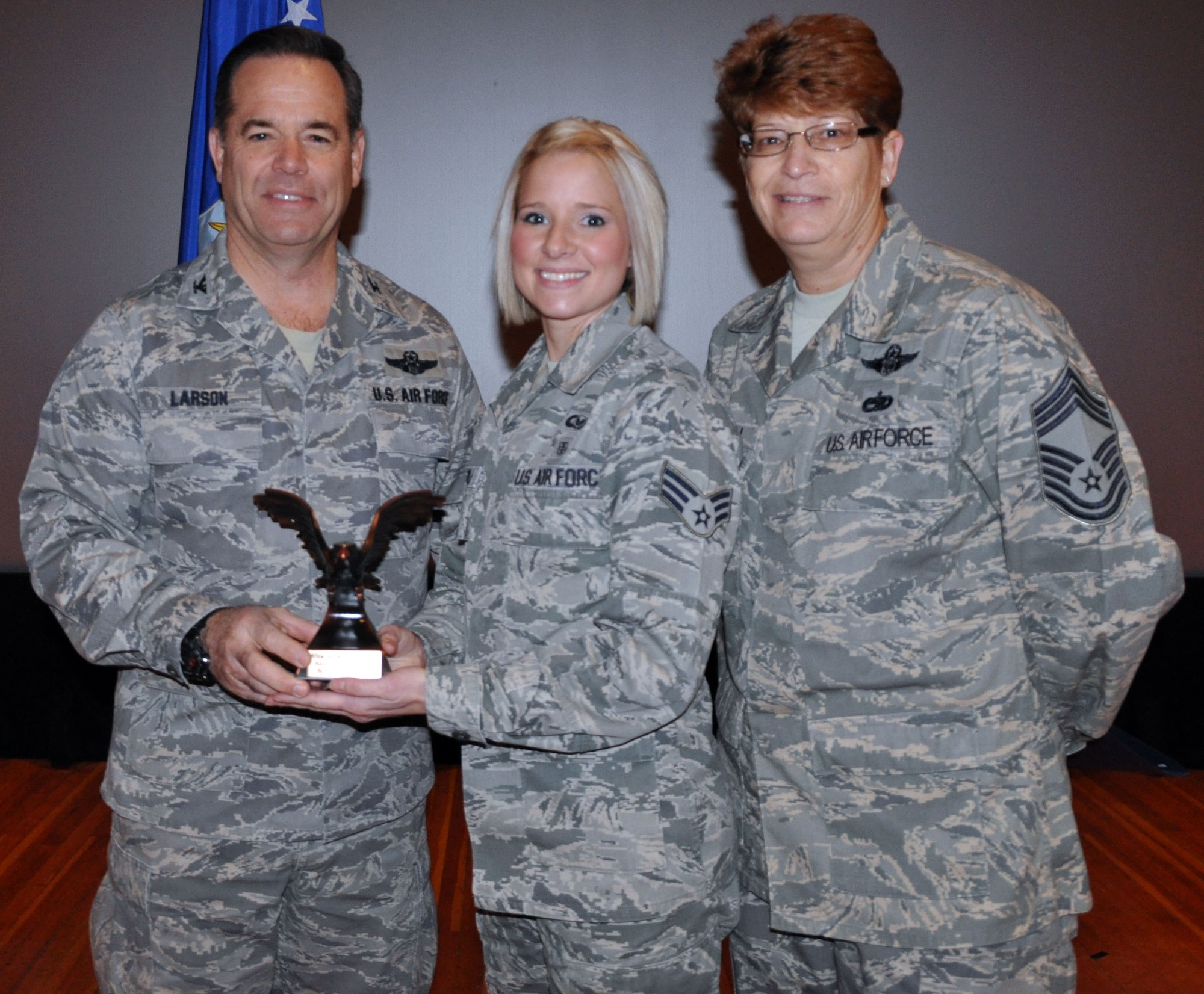 Col. Mark S. Larson, commander of the 931st Air Refueling Group, and Chief Master Sgt. Kathleen E. Lowman, 931st Air Refueling Group superintendent, congratulate Senior Airman Leirin Andra as Airman of the Quarter for the 4th quarter of 2012 during the 931st Air Refueling Group commander's call at McConnell Air Force Base, Kan, Jan. 6, 2013.  (U.S. Air Force photo by 1st Lt. Zach Anderson)