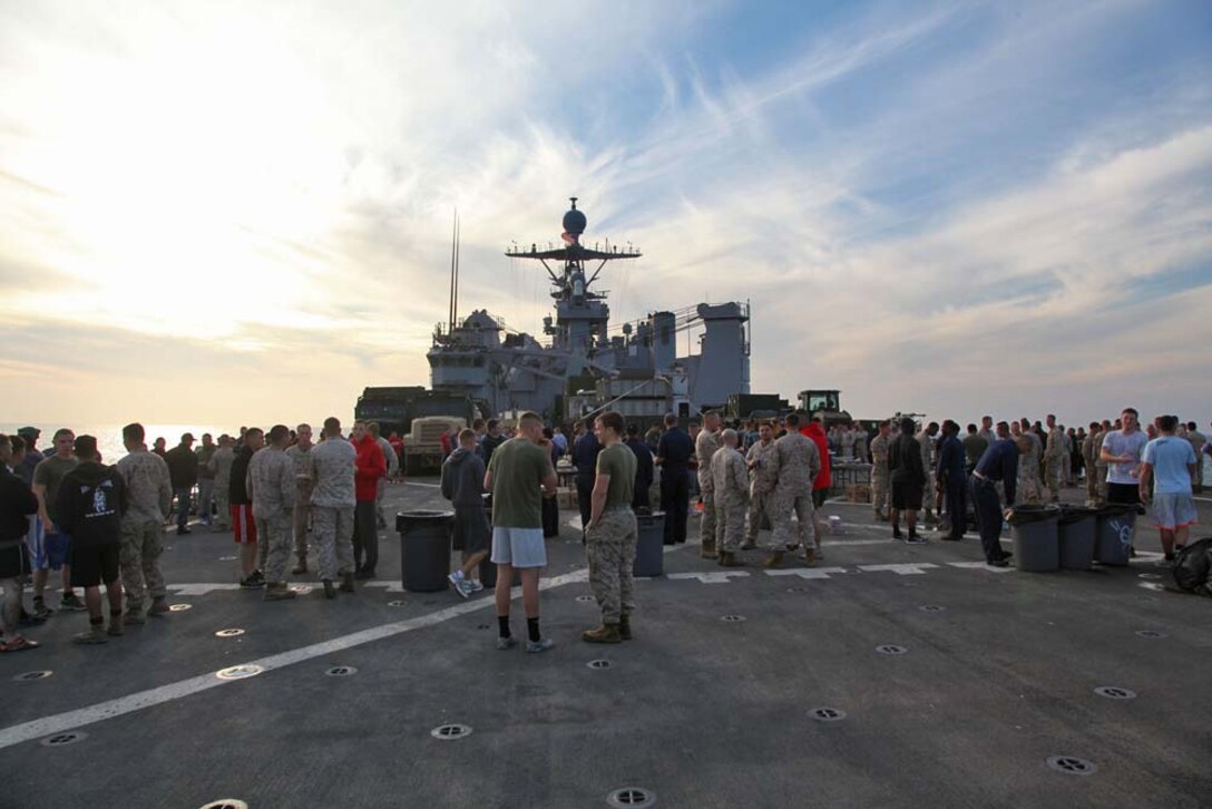 Marines and sailors aboard USS Rushmore attend a steel beach picnic, held to build crew's morale, on the shipâ€™s flight deck, Dec. 2. The 15th MEU is deployed as part of the Peleliu Amphibious Ready Group as a U.S. Central Command theater reserve force, providing support for maritime security operations and theater security cooperation efforts in the U.S. 5th Fleet area of responsibility. (U.S. Marine Corps photo by Cpl. Timothy R. Childers)