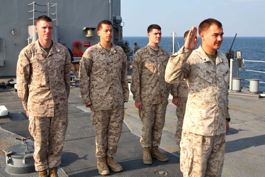 Corporal Robert T. Ruiz, forward observer, Air Naval Gunfire Liaison Company, Command Element, 15th Marine Expeditionary Unit, re-enlists into the Marine Corps aboard the USS Rushmore, Dec. 30. The 15th MEU is deployed as part of the Peleliu Amphibious Ready Group as a U.S. Central Command theater reserve force, providing support for maritime security operations and theater security cooperation efforts in the U.S. 5th Fleet area of responsibility. Ruiz, 24, is from San Bernardino, Calif. (U.S. Marine Corps photo by Cpl. Timothy R. Childers/Released)