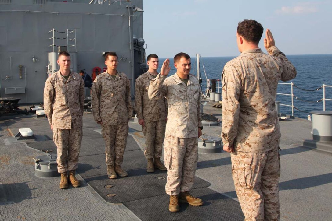 Corporal Robert T. Ruiz, forward observer, Air Naval Gunfire Liaison Company, Command Element, 15th Marine Expeditionary Unit, re-enlists into the Marine Corps aboard the USS Rushmore, Dec. 30. The 15th MEU is deployed as part of the Peleliu Amphibious Ready Group as a U.S. Central Command theater reserve force, providing support for maritime security operations and theater security cooperation efforts in the U.S. 5th Fleet area of responsibility. Ruiz, 24, is from San Bernardino, Calif. (U.S. Marine Corps photo by Cpl. Timothy R. Childers/Released)