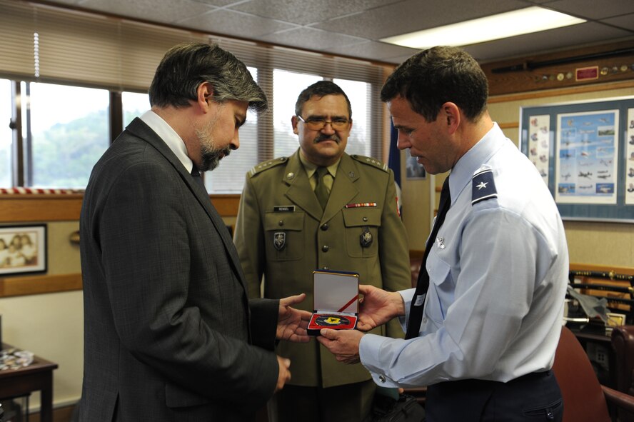 U.S. Air Force Brig. Gen. Matt Molloy, 18th Wing commander, gives Cyryl Kozaczewski, Ambassador Extraordinary and Plenipotentiary of the Republic of Poland to Japan, a large 18th Wing coin as a gift during his visit to Kadena Air Base, Japan, Jan. 7, 2013. Molloy gave Kozaczewski a tour of the base which strengthens ties between U.S. and allied nations. Kozaczewski has spent time as the Polish Civilian Representative to North Atlantic Treaty Orginization and from that experience he has some understanding of military issues. The Polish Embassy is also the current representative for NATO in the Asia-Pacific Region. (U.S. Air Force photo/Airman 1st Class Malia Jenkins)