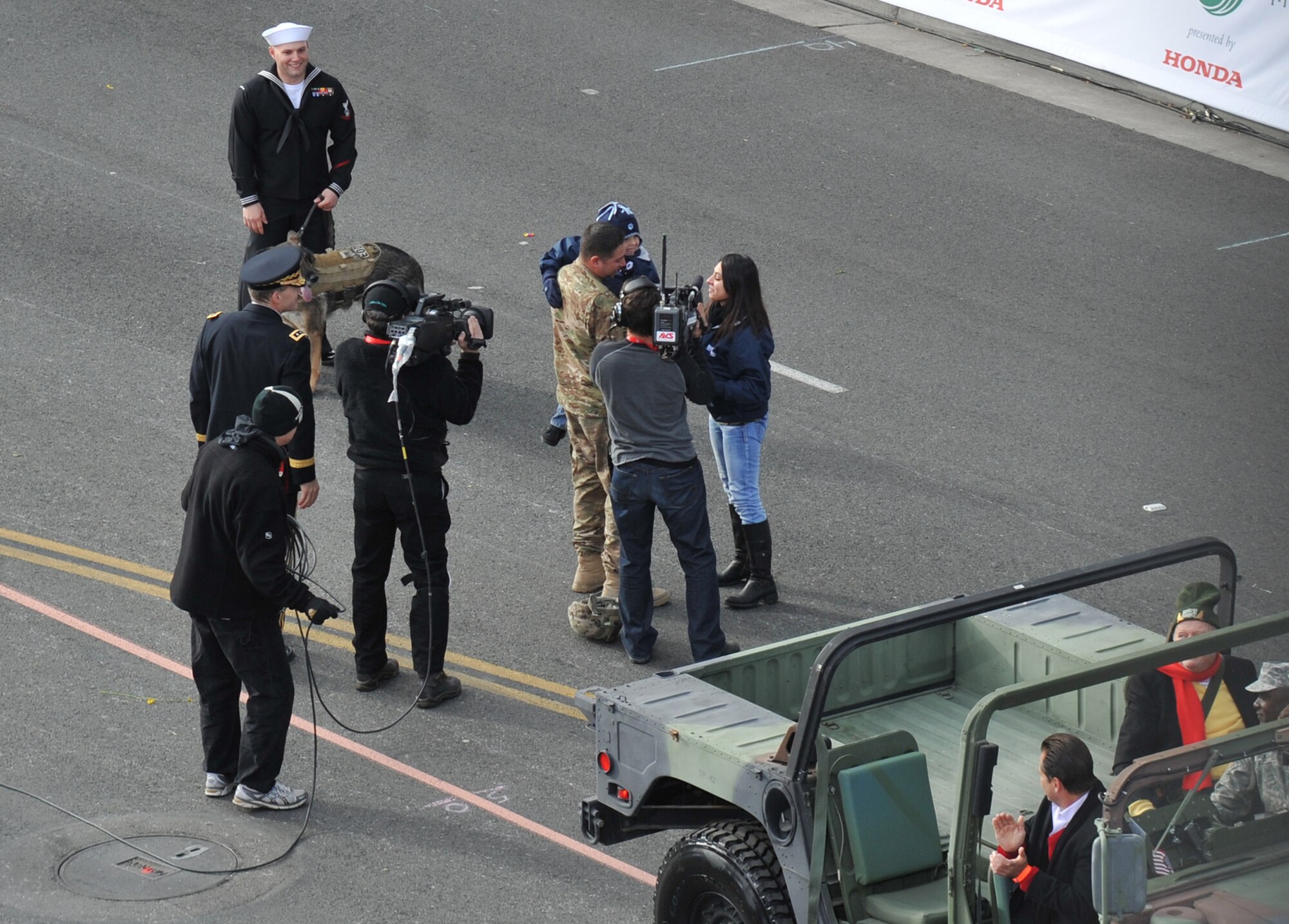 Television crews catch Army Sgt. First Class Eric Pazz surprising his family during the Tournament of Roses parade, Jan. 1. The family was told that they won a contest to attend the parade and didn’t know that Pazz, who was deployed in Afghanistan, would be there. (Photo by Sarah Corrice)